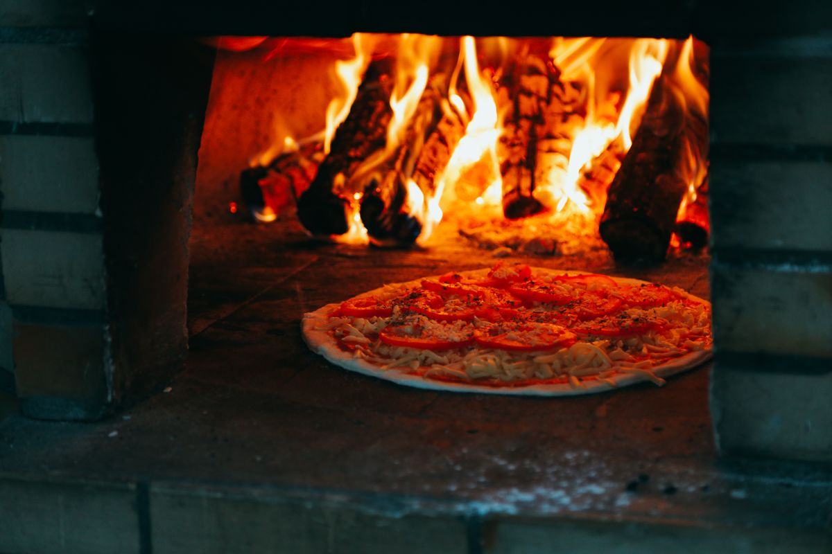 Four à pizza à bois professionnel en pleine chauffe